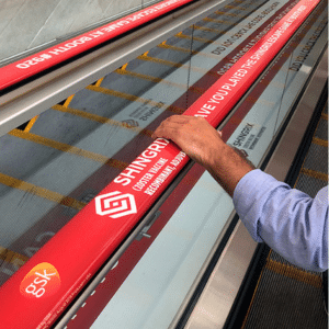 hand holding right escalator handrail. Adrail red