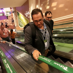 man riding up escalator holding adrail handrail